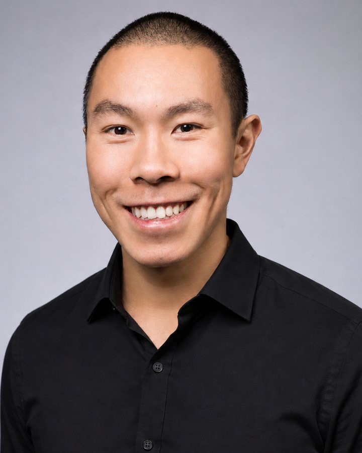 Portrait of Nathan Nguyen, smiling, in a black shirt